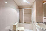 This bathroom features a clean and modern design with neutral-colored tiles.