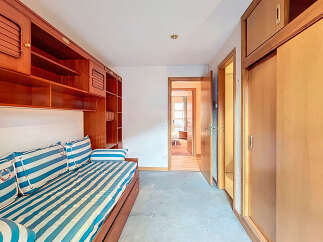 Discover a cozy bedroom with a nautical theme, featuring a comfortable striped bed and stylish built-in wooden storage.
