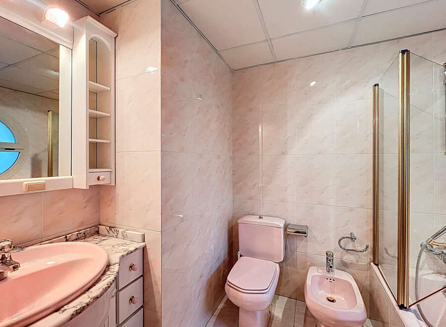 Step into this charming bathroom featuring a unique pink color scheme.
