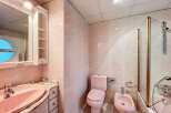 Step into this charming bathroom featuring a unique pink color scheme.