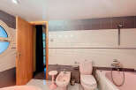 Step into this charming bathroom featuring a unique pink toilet and bidet, adding a touch of retro flair.
