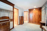 Step into a spacious bedroom with classic wooden furniture.
