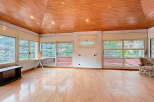 Discover this stunning property featuring a unique wooden ceiling and expansive windows that flood the space with natural light.