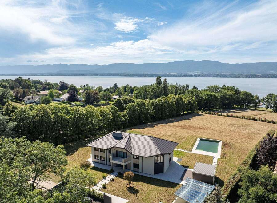 This stunning property boasts a modern architectural design with a private pool and breathtaking lake views.