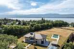This stunning property boasts a modern architectural design with a private pool and breathtaking lake views.