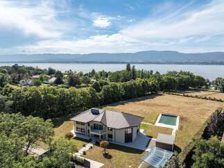 This stunning property boasts a modern architectural design with a private pool and breathtaking lake views.