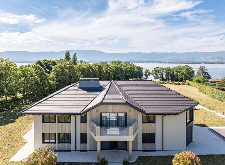 A luxurious house boasts a modern design with a stunning balcony offering breathtaking lake views.