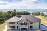 A luxurious house boasts a modern design with a stunning balcony offering breathtaking lake views.