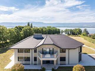 A luxurious house boasts a modern design with a stunning balcony offering breathtaking lake views.