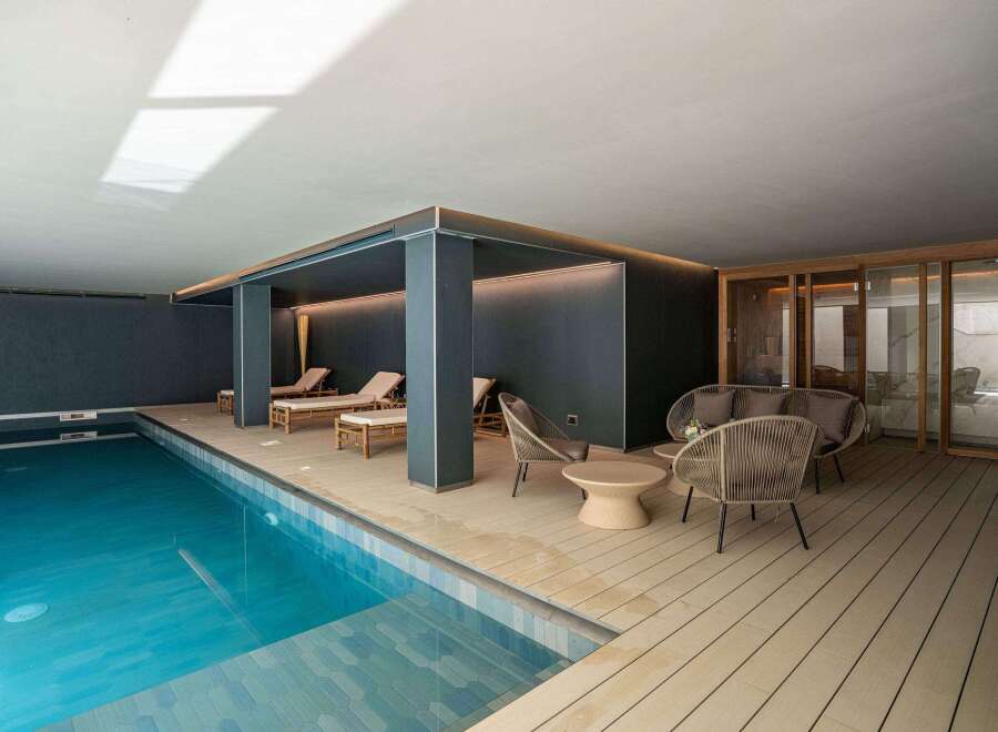 Experience luxury living with this stunning property featuring an indoor pool and relaxing lounge area.