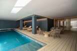 Experience luxury living with this stunning property featuring an indoor pool and relaxing lounge area.