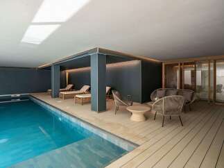 Experience luxury living with this stunning property featuring an indoor pool and relaxing lounge area.