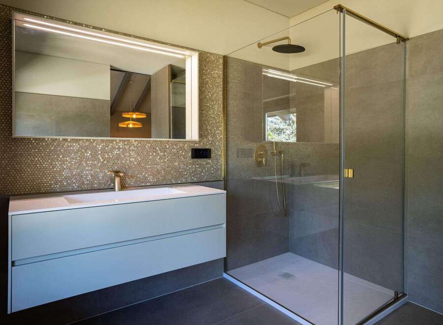 This modern bathroom features a walk-in shower with sleek glass enclosure and stylish fixtures.