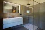 This modern bathroom features a walk-in shower with sleek glass enclosure and stylish fixtures.