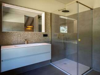 This modern bathroom features a walk-in shower with sleek glass enclosure and stylish fixtures.