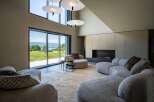This luxurious living room features a plush, modular sofa arranged around a soft, textured rug, creating a cozy and inviting space.