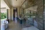 This luxurious bathroom boasts modern design elements, including a standalone bathtub with stylish fixtures and a glass-enclosed shower featuring stunning marble walls.