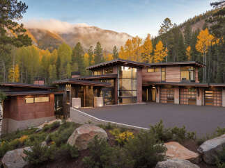 This modern mountain home features stunning natural wood exteriors and expansive windows to capture breathtaking views.