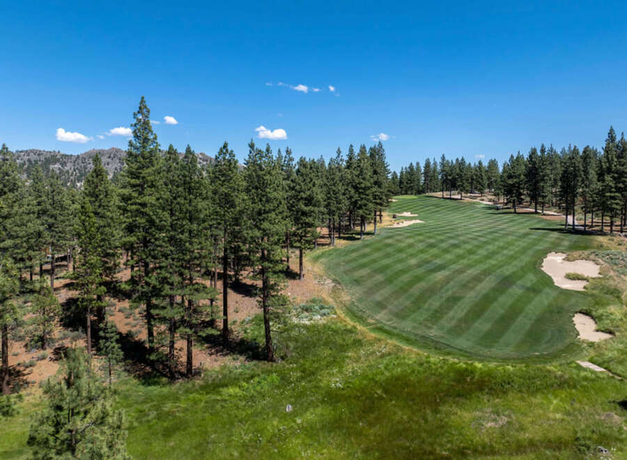 Discover luxury living with golf course frontage! This stunning view showcases the lush green fairway surrounded by towering pines.