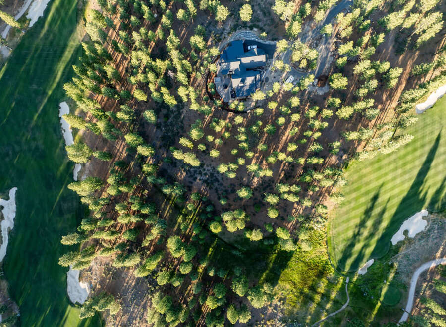 An aerial view shows a luxury home nestled within a golf course community.