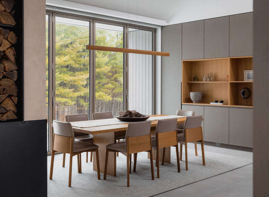 This stunning dining room boasts a sleek, modern design with floor-to-ceiling windows offering breathtaking views of the surrounding landscape.