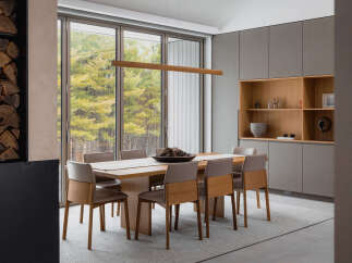 This stunning dining room boasts a sleek, modern design with floor-to-ceiling windows offering breathtaking views of the surrounding landscape.