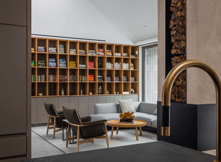 This stunning living room boasts a built-in wooden bookcase filled with books and media, creating a warm and inviting atmosphere.
