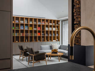 This stunning living room boasts a built-in wooden bookcase filled with books and media, creating a warm and inviting atmosphere.