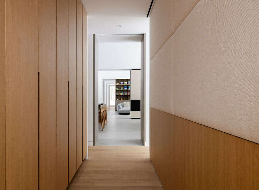 This hallway boasts a sleek and modern design, featuring light wood paneling and built-in cabinetry.