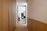 This hallway boasts a sleek and modern design, featuring light wood paneling and built-in cabinetry.