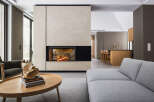 This stunning modern home boasts a sleek, minimalist design with a focal point of a contemporary fireplace encased in light beige plaster.