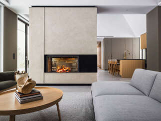 This stunning modern home boasts a sleek, minimalist design with a focal point of a contemporary fireplace encased in light beige plaster.