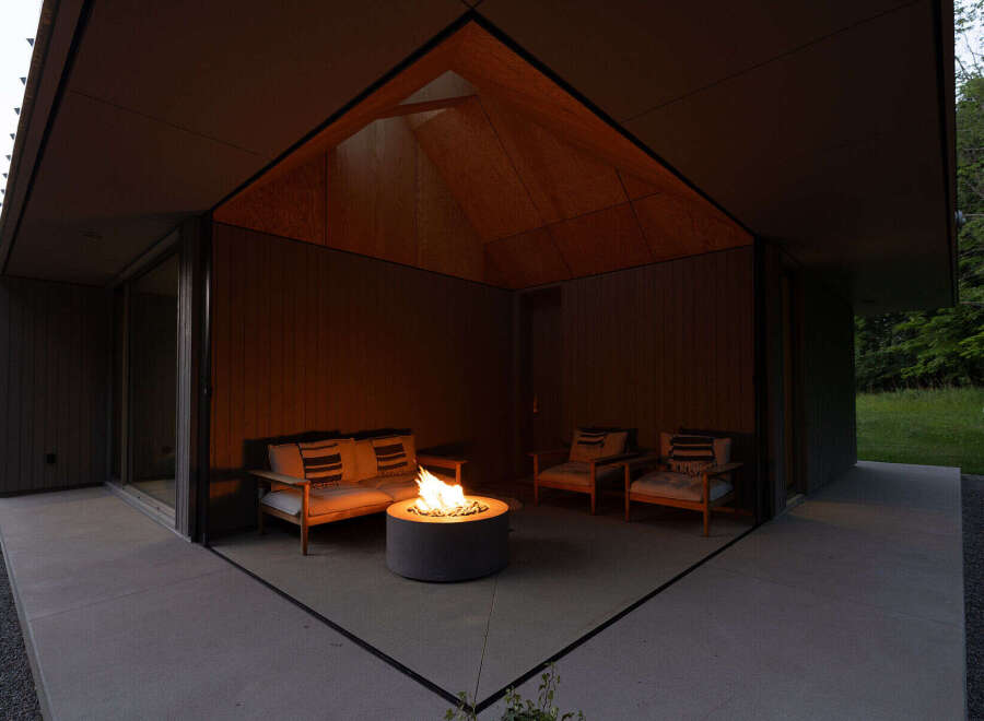 This modern home features a stunning outdoor patio with a built-in fire pit, perfect for relaxing evenings.