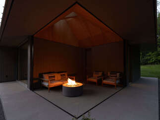 This modern home features a stunning outdoor patio with a built-in fire pit, perfect for relaxing evenings.