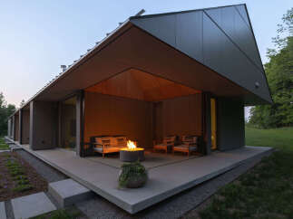 This modern home features a stunning outdoor patio area complete with a fire pit, perfect for relaxing evenings.
