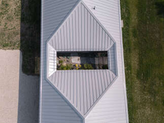 This property features a unique architectural design with a light gray metal roof and a central skylight illuminating an interior courtyard.