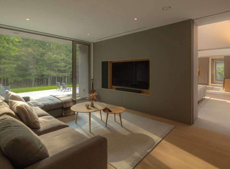 Experience luxury living in this stunning property, featuring a modern living room with a large sectional sofa and a sleek entertainment center.