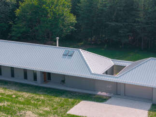 This modern home boasts a sleek, contemporary design with a striking metal roof.