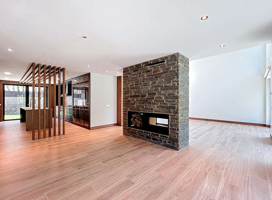 This open-concept living space boasts a striking stone fireplace, serving as a focal point and adding warmth.