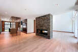 This open-concept living space boasts a striking stone fireplace, serving as a focal point and adding warmth.