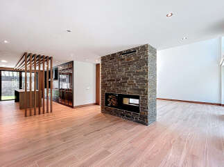 This open-concept living space boasts a striking stone fireplace, serving as a focal point and adding warmth.