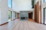 This expansive living room boasts soaring ceilings and abundant natural light, creating an airy and inviting atmosphere.