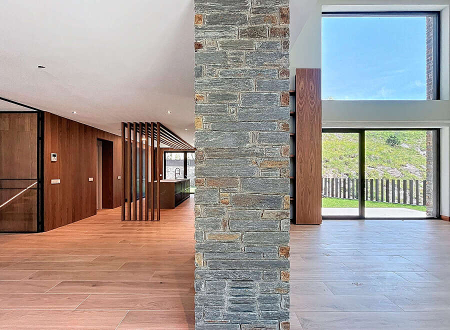 This modern home boasts an open floor plan with natural light pouring through expansive windows, highlighting the beautiful hardwood floors.