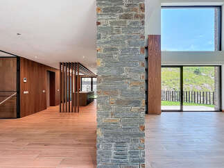 This modern home boasts an open floor plan with natural light pouring through expansive windows, highlighting the beautiful hardwood floors.