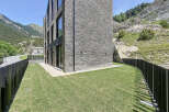 This modern mountain home boasts a stunning stone facade and expansive windows, perfectly blending with the natural landscape.