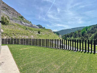 Discover this exceptional property with a meticulously maintained lawn and modern fence, set against a breathtaking mountain backdrop.