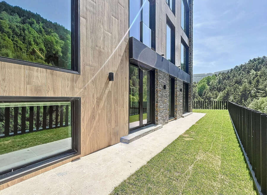This is a modern property featuring a facade with a combination of wood-like panels and stone accents.