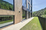 This is a modern property featuring a facade with a combination of wood-like panels and stone accents.