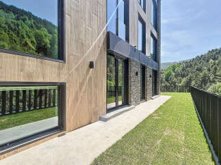 This is a modern property featuring a facade with a combination of wood-like panels and stone accents.