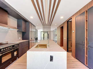 This modern kitchen features a large island with a sink, custom cabinetry, and a high-end Bertazzoni range.
